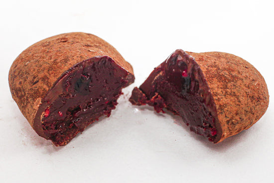 Sustainable Raspberry chocolate truffle by Nelson's Chocofellar. Minimal chocolate packaging, sustainable ingredients
